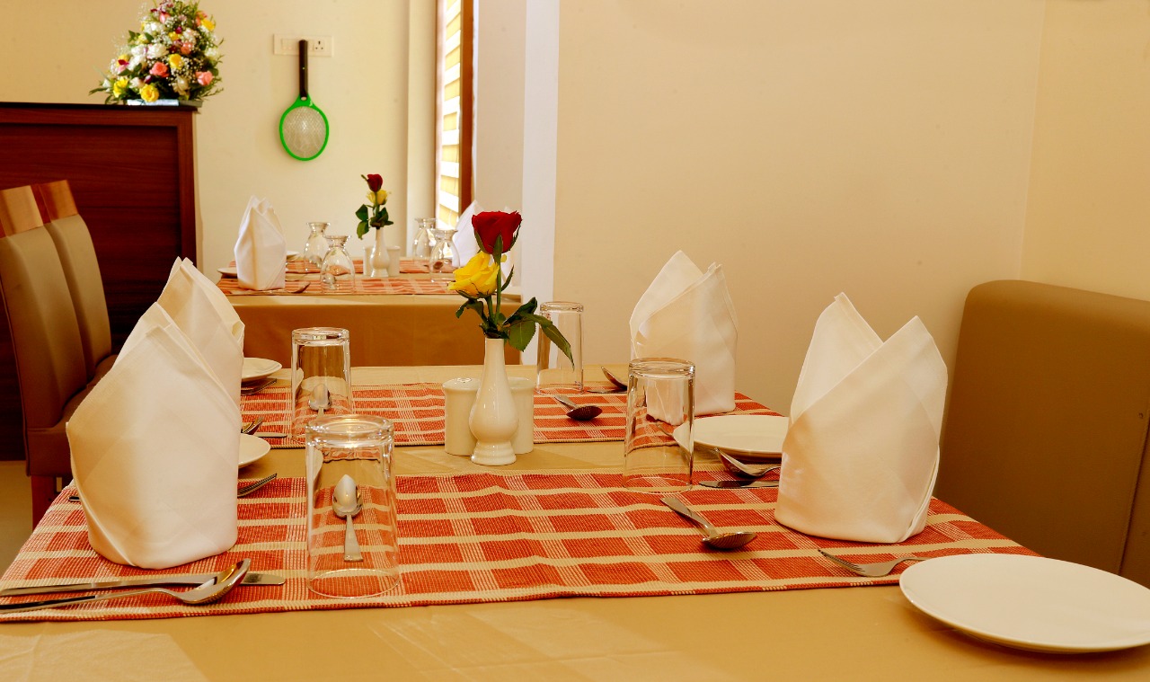 Elegantly arranged dining table with fresh roses and glassware